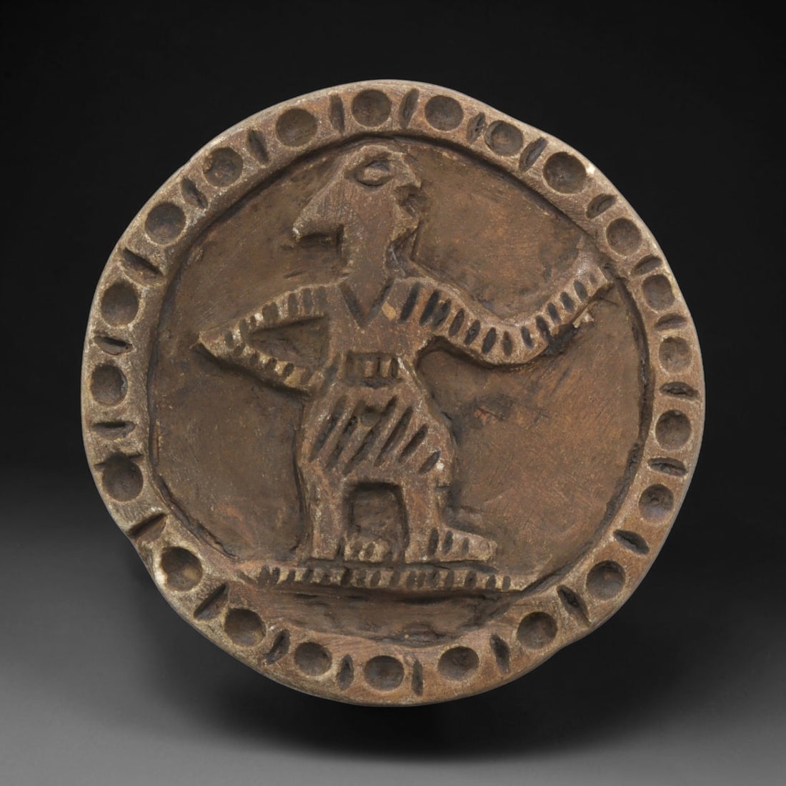 Ancient Steatite Plaque - Near Eastern Anthropomorphic Relief, 37ZY: Carved from steatite, this circular plaque features a relief depiction of an anthropomorphic figure, rendered in a stylized, schematic Near Eastern artistic tradition. The figure stands in a dynamic p