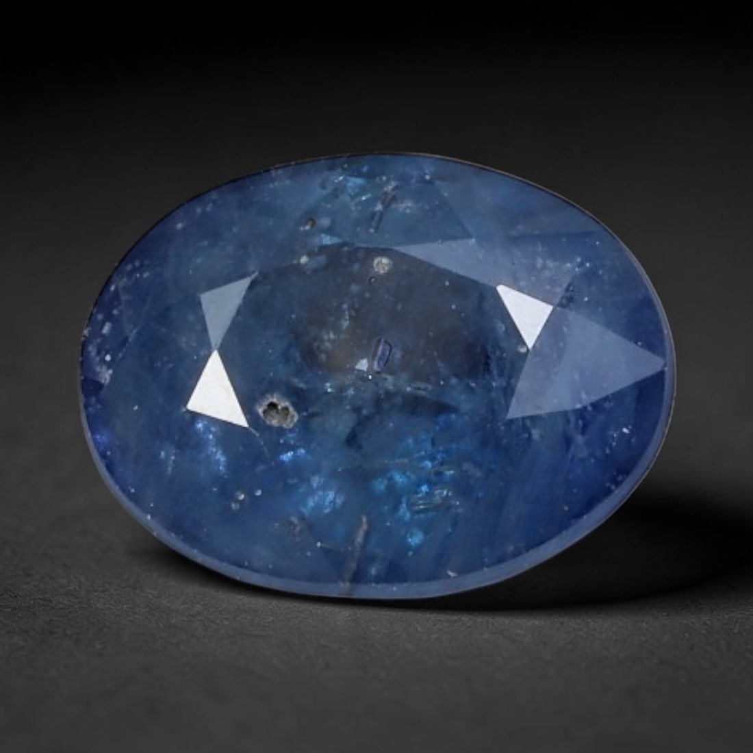 2.44 Carats Natural Blue Sapphire - Oval Faceted Loose Gemstone, 31XB: Natural oval-faceted blue sapphire gemstone, a genuine corundum specimen with a rich, deep royal blue hue. This stone features natural internal inclusions, mineral deposits, and characteristic growth 