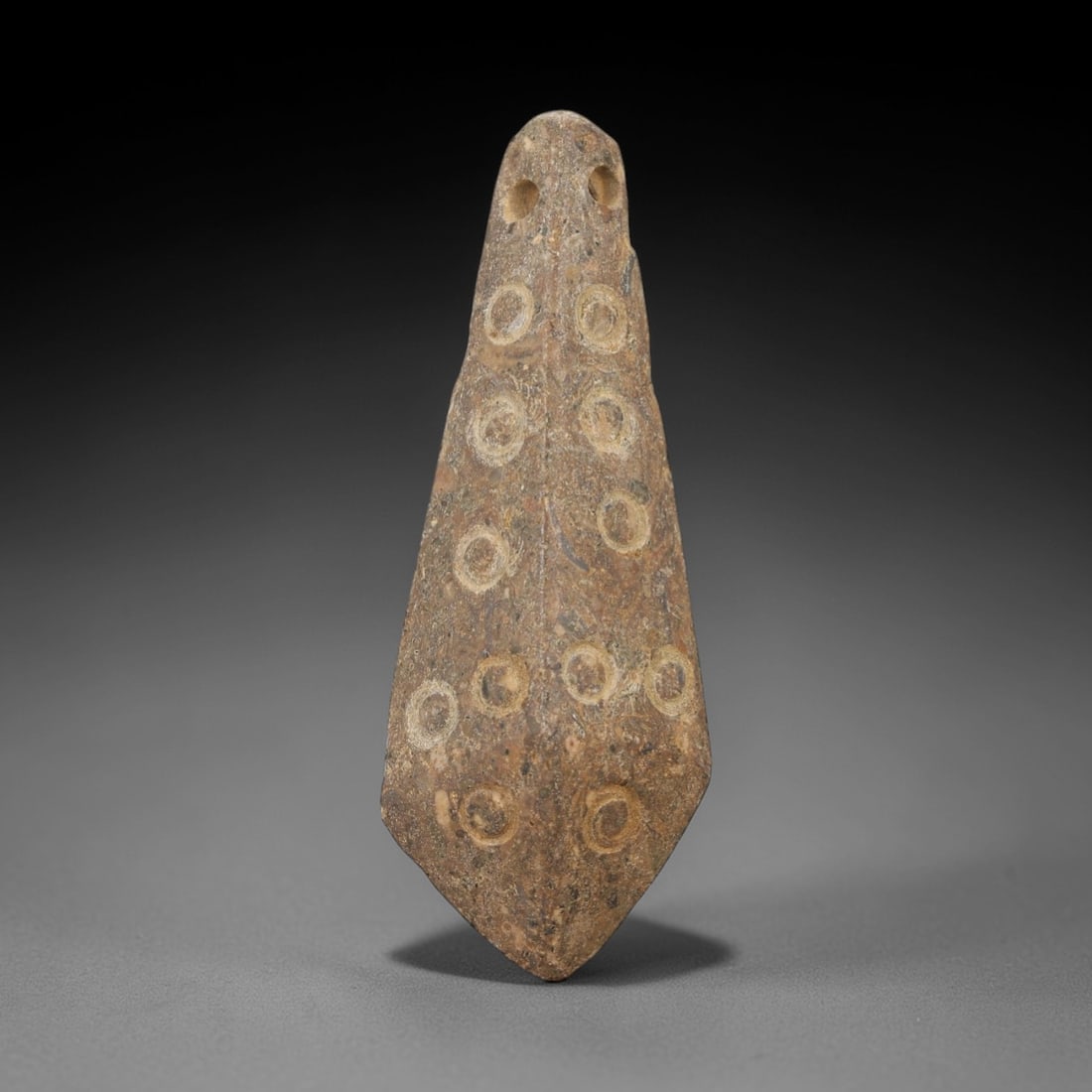 Ancient Stone Eye Amulet - Near Eastern Pendant, 20AE: This artifact is a carved stone eye amulet of Near Eastern origin, crafted from a mottled brown stone with natural mineral inclusions and earthy patination. Its elongated, teardrop-shaped form feature