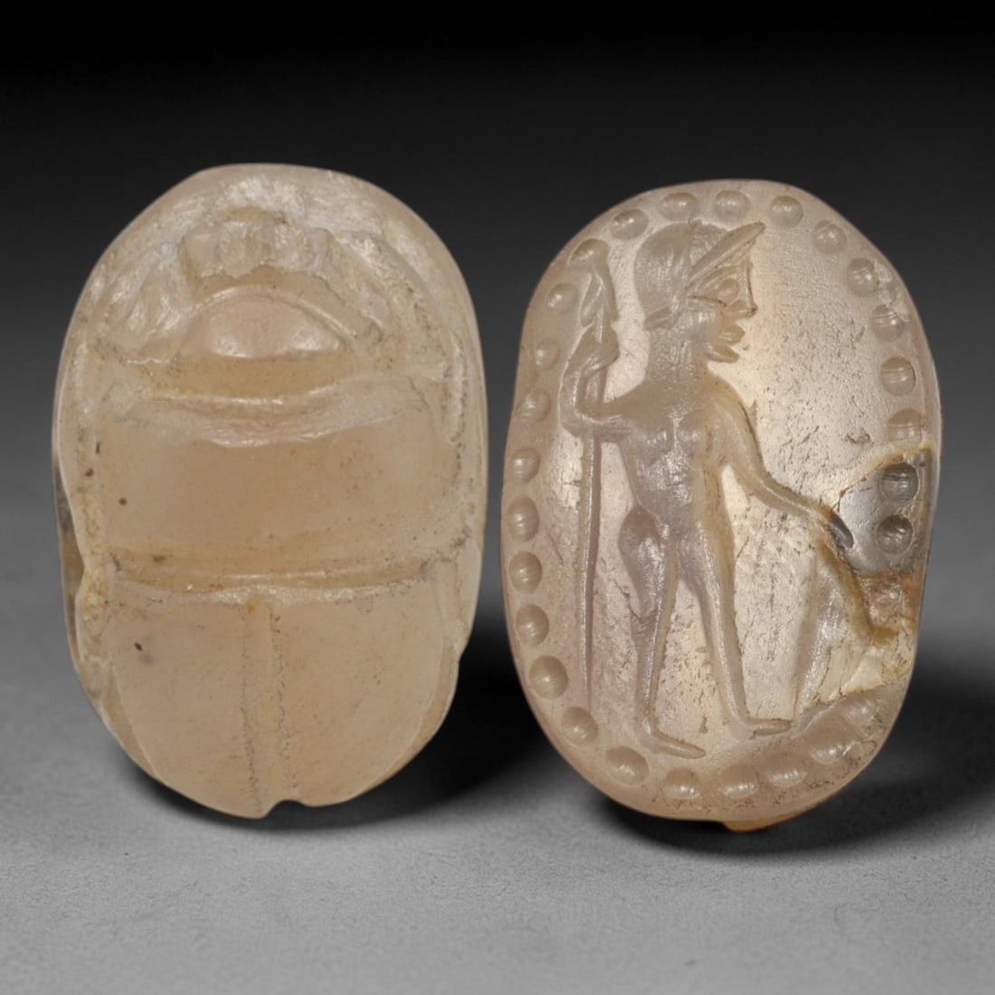 Ancient Chalcedony Scarab - Near Eastern Warrior Figural Seal, 81AS: This artifact is hand-carved from pale translucent chalcedony, utilizing traditional ancient seal craftsmanship consistent with Near Eastern or Phoenician Iron Age traditions. The object takes the for