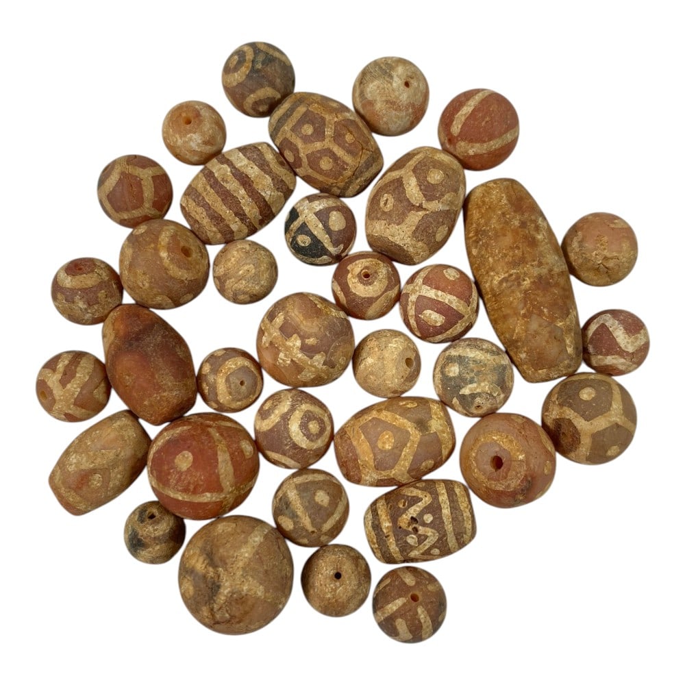 A Lot of 35 Ancient Etched Carnelian Beads, Gandhara Style, 69AA: This collection features 35 ancient etched carnelian beads, characteristic of Gandhara-period craftsmanship. Crafted from natural carnelian, they display warm reddish-brown and terracotta hues, adorne