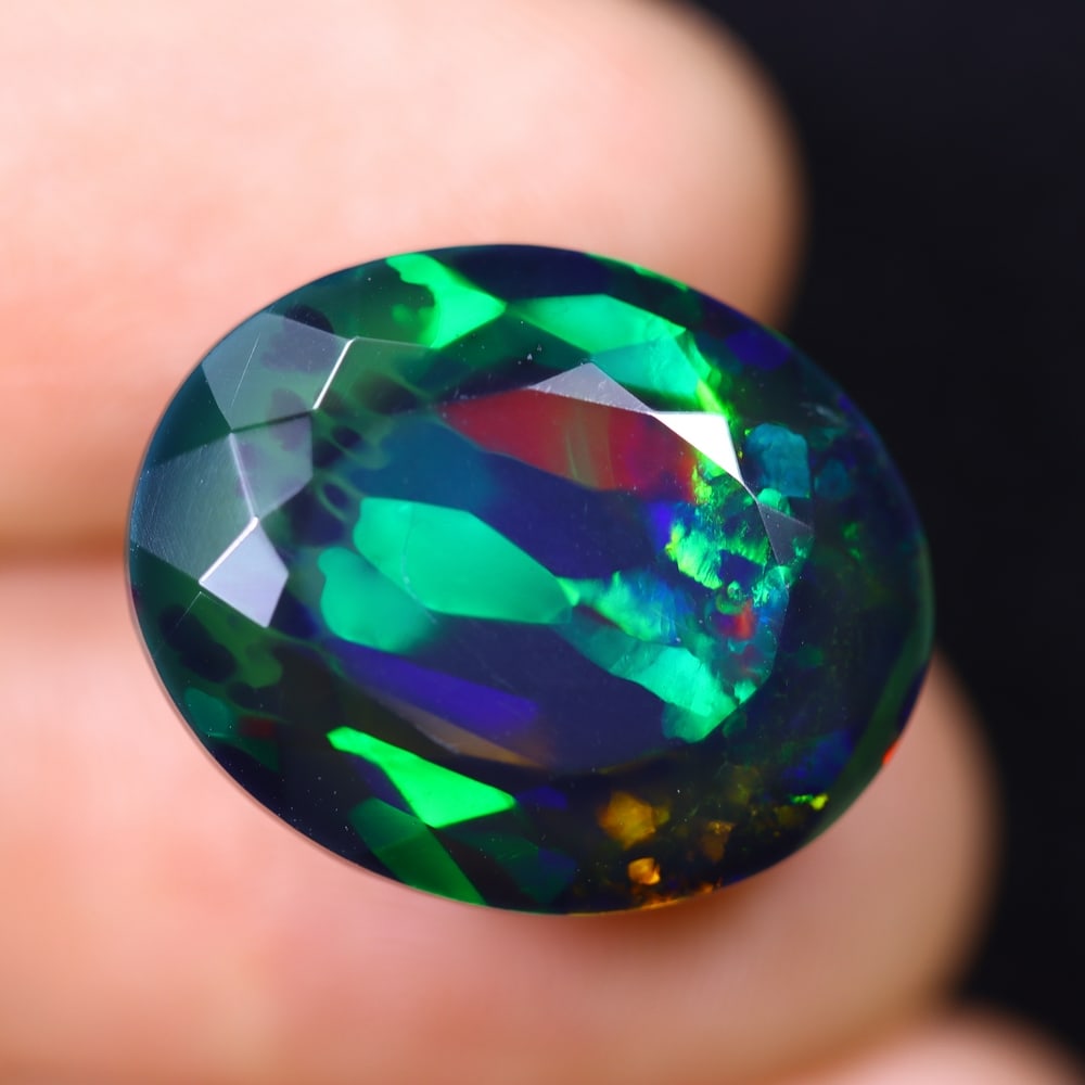*11.55Ct Faceted Welo Black Opal Polished - Ethiopian Opal, 831B: ThousandPlanet Auction Subject: Natural Ethiopian Welo Black Opal Origin: Ethiopia Carat Weight: 11.55Ct Dimension: 18.4x15x10 mm Treatment: Smoked Type: Faceted, Polished <