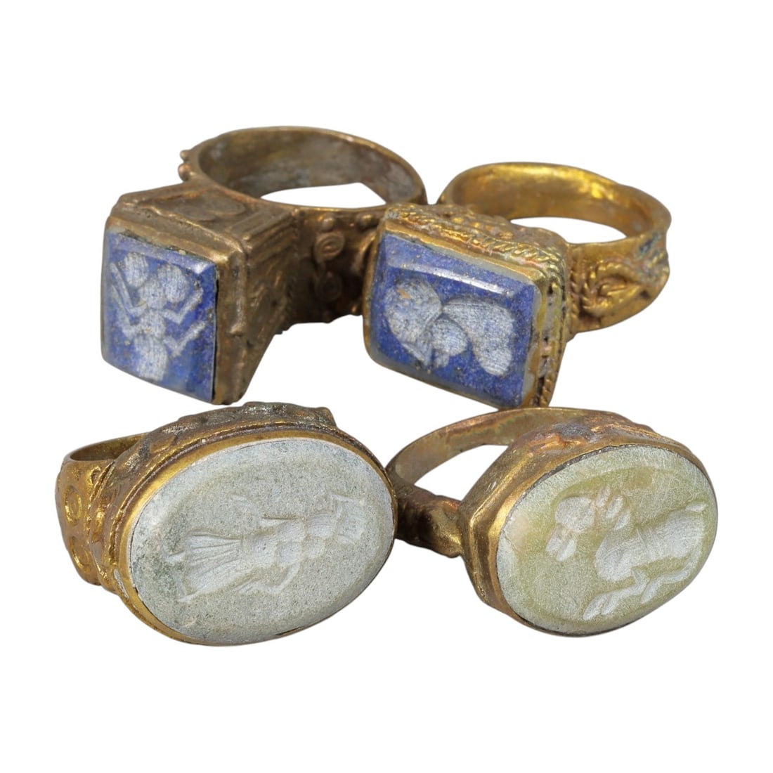 Lot of 4 Antique Qajar Period Gilt Intaglio Signet Rings, 98AC: This is a collection of four gilt-metal rings dating to the Qajar period (19th century), each set with a carved intaglio seal stone, reflecting the era's enduring tradition of signet jewelry. The ring