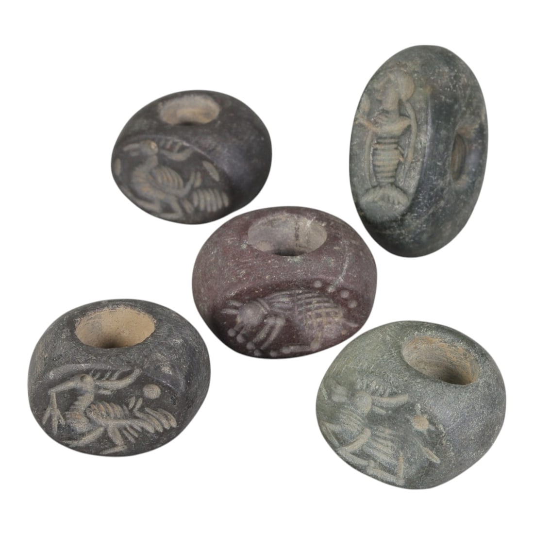 Lot of 5 Sasanian Stone Stamp Seals, Circa 3rd-7th Century CE, 97AE: Comprising five seals carved from stone of varying dark grey, greenish, and reddish tones, exhibiting natural patina and surface wear consistent with ancient use. Each seal is of flattened disc or ova