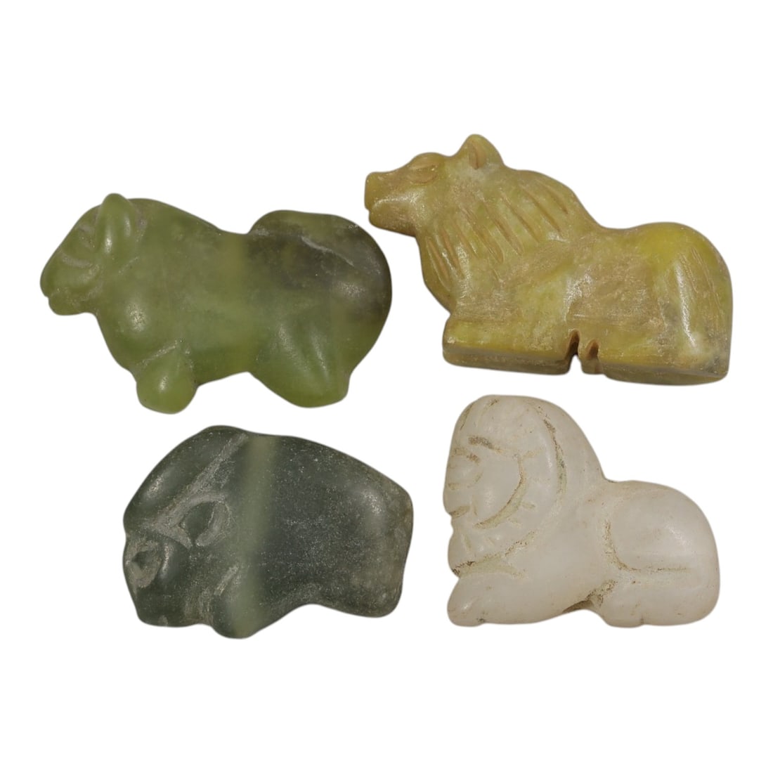 Lot of 4 Ancient Bactrian Zoomorphic Stone Amulets, Circa 3rd-1st Millennium BCE, 80AE: The group comprises four carved zoomorphic amulets depicting recumbent quadrupeds, likely stylized bulls or lions, characteristic of ancient Bactrian art. The pieces are worked in varied stone tones: 