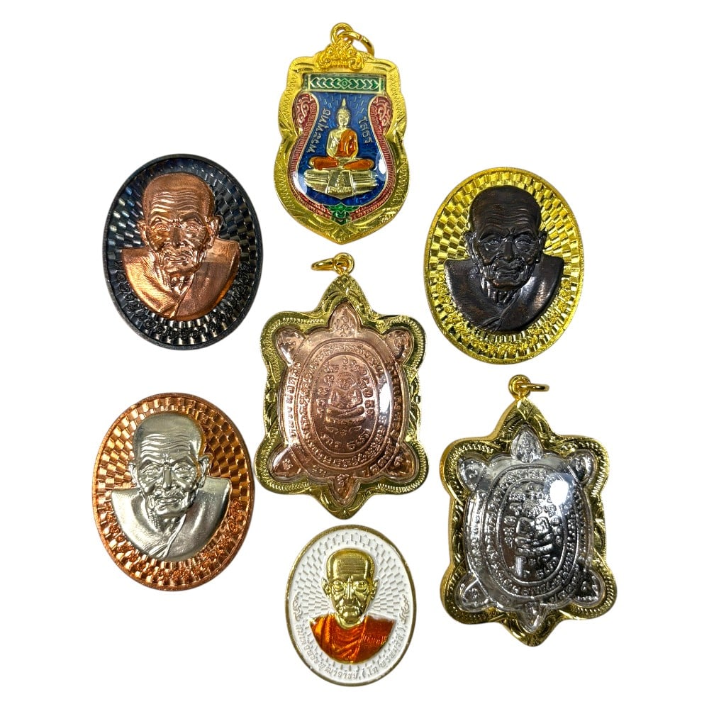 A Lot of 7 Vintage Gilt Thai Buddhist Amulets with Enamel Accents, 22AA: Comprising seven pendants of varying shapes and sizes, ranging from 3.5 to 6 cm in height. Each amulet is encased in ornate gilt metal frames, some accented with colorful enamelwork. The group include