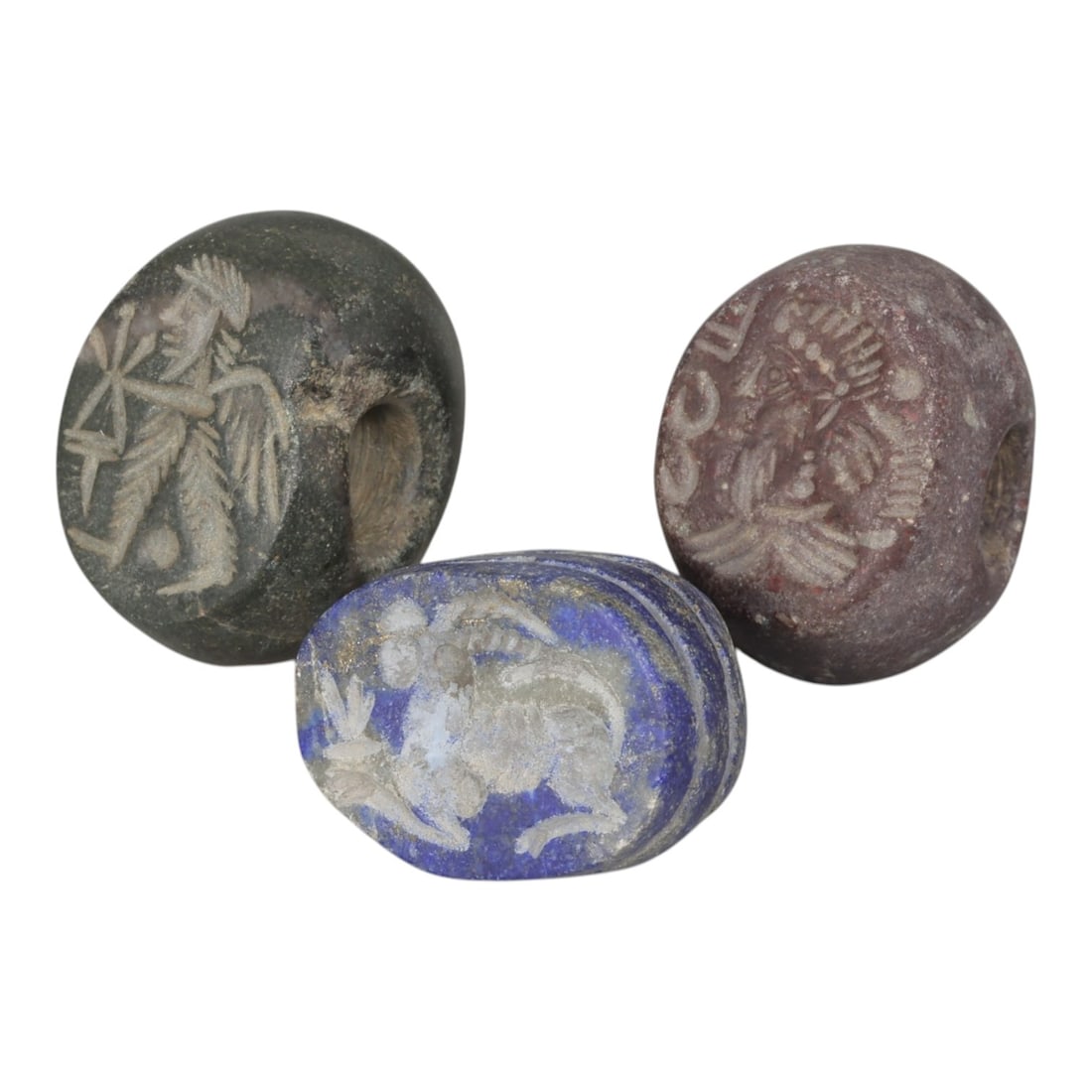 Lot of 3 Sasanian Stone and Lapis Lazuli Stamp Seals, Circa 3rd-7th Century CE, 96AE: Comprising three seals, including two carved from stone (dark green and reddish tones) and one from lapis lazuli, all exhibiting natural patina and surface wear consistent with age. Each seal is of ro