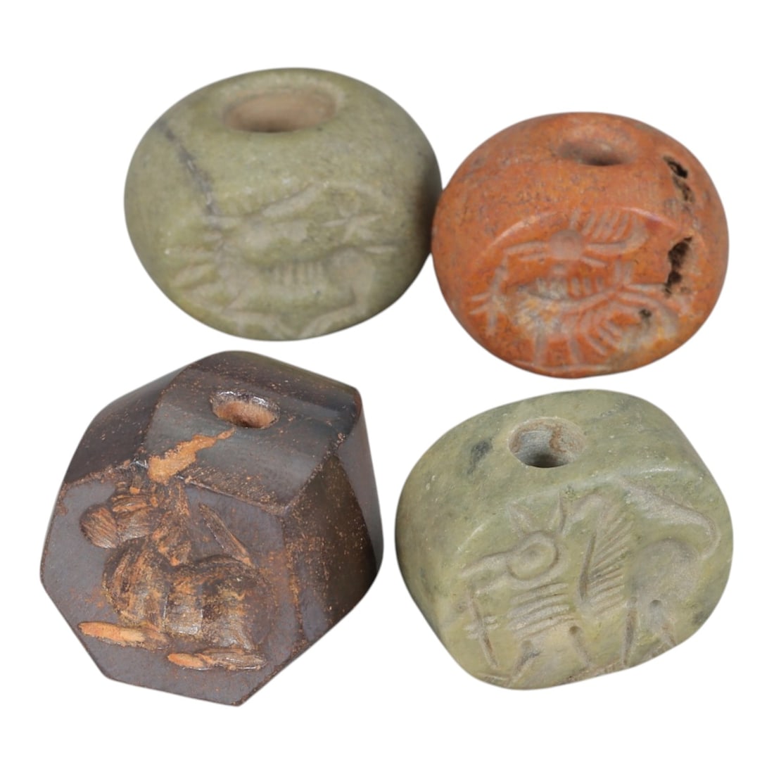 Lot of 4 Sasanian Stone Stamp Seals, Circa 3rd-7th Century CE, 100AE: Comprising four seals carved from stone of varying colors, including green, orange, and dark brown tones, exhibiting natural patina and surface wear consistent with age. The seals are of varied forms: