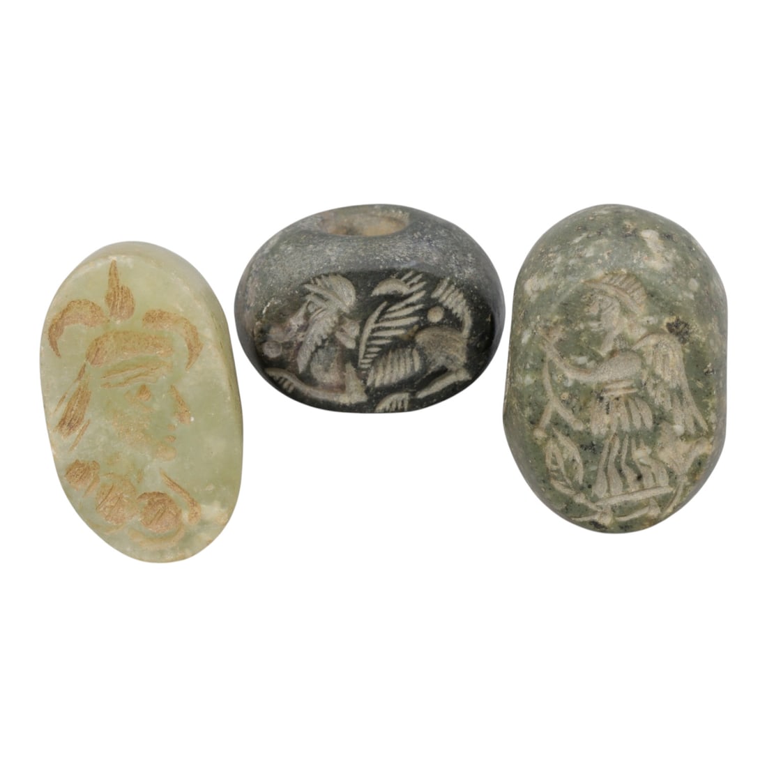 Lot of 3 Ancient Near Eastern Stone Stamp Seals, Circa Late Antiquity, 1WM: A group of three hand-carved stamp seals crafted from varied stones, including pale green and dark grey varieties, exhibiting natural patination, surface wear, and subtle weathering consistent with ag