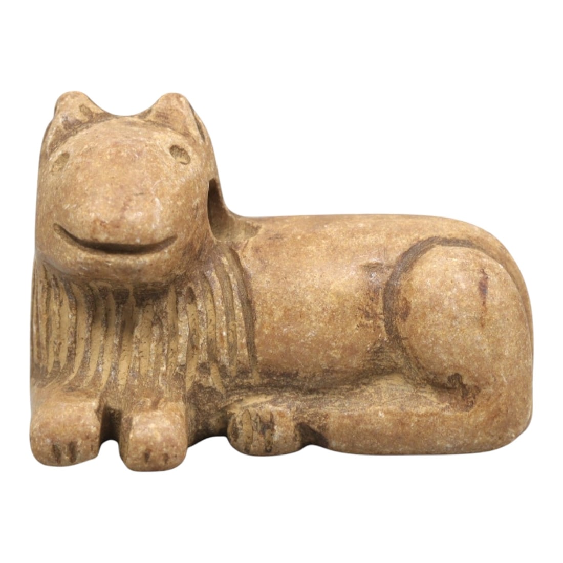 Ancient Stone Feline Figurine - Near Eastern Amulet, 4ZR: Carved from warm tan stone, this reclining feline figurine features a stylized head with incised eyes, pointed ears, and a gently curved mouth. The neck displays linear incised detailing suggesting a 