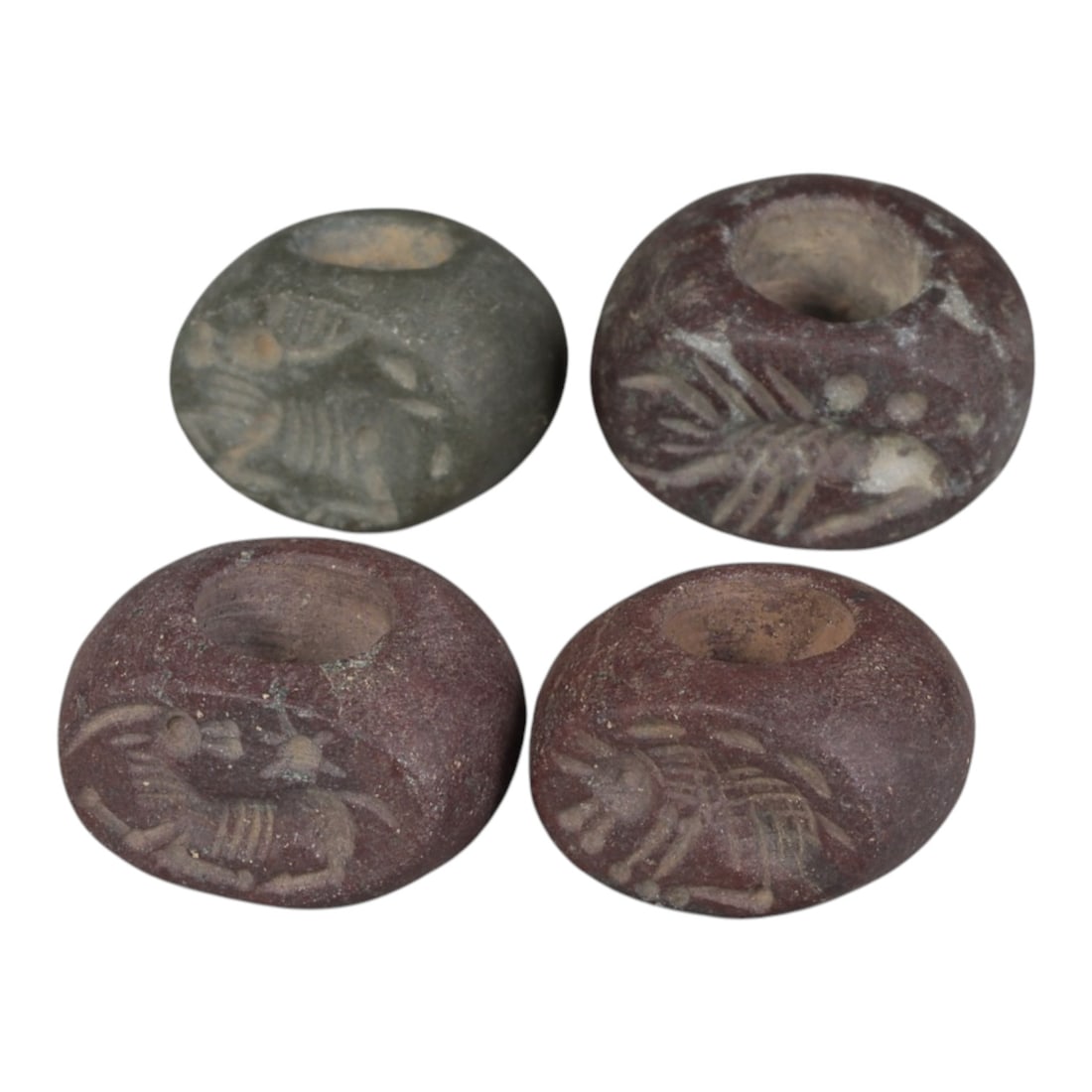 Lot of 4 Ancient Sasanian Stone Stamp Seals, Circa 3rd-7th Century CE, 73WP: A collection of four Sasanian period stamp seals, carved from varied dark and reddish stone types, each featuring a central drilled hole for suspension. The seals display characteristic Sasanian zoomo