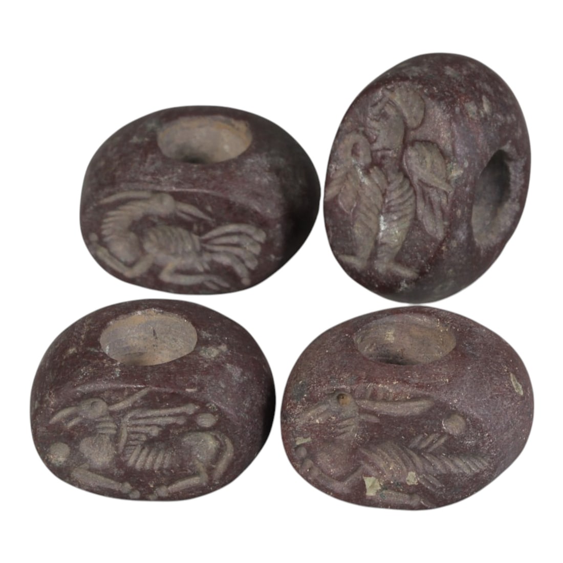 Lot of 4 Ancient Sasanian Jasper Stamp Seals, Circa 3rd-7th Century CE, 71WP: A collection of four Sasanian period stamp seals, carved from rich reddish-brown jasper stone, each featuring a central drilled hole for suspension. The seals display characteristic Sasanian iconograp