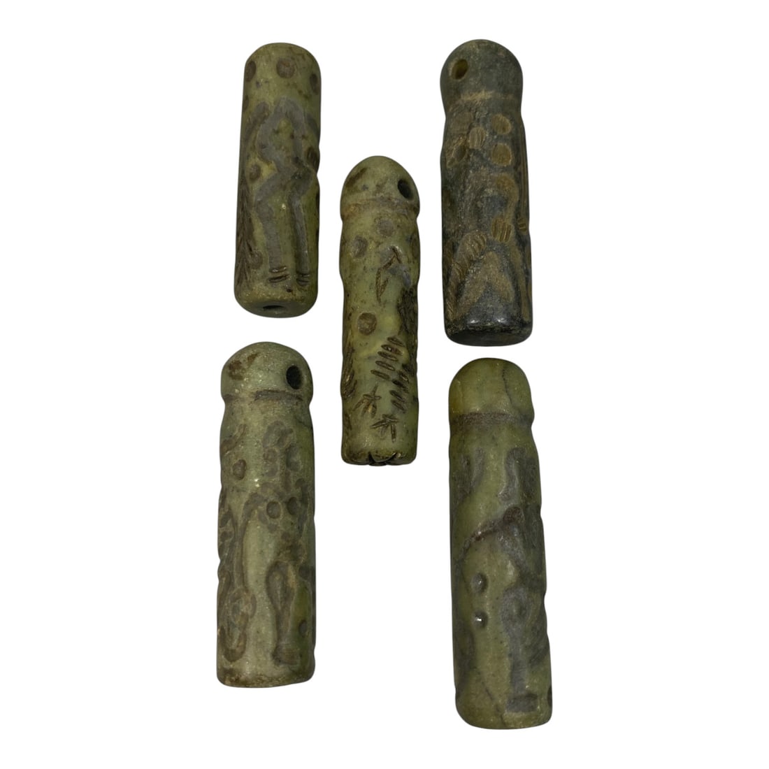 A Lot of 5 Ancient Mesopotamian Serpentine Cylinder Seals, 44WP: A curated lot of five ancient Mesopotamian-style cylinder seals, carved from serpentine stone with natural patination and wear consistent with age. Each seal features a cylindrical form, most with dom