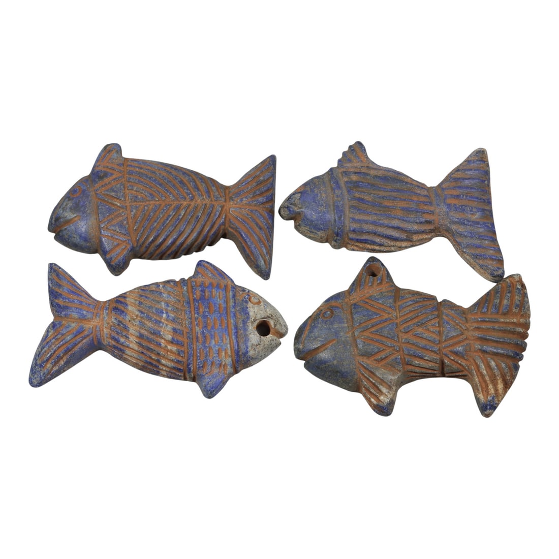 Lot of 4 Ancient Near Eastern Lapis Lazuli Fish Amulets, Circa 1st Millennium BCE, 41WP: A curated lot of four ancient Near Eastern fish amulets, carved from lapis lazuli stone. Each piece is rendered in the form of a stylized fish, with incised linear and geometric patterns in reddish pi