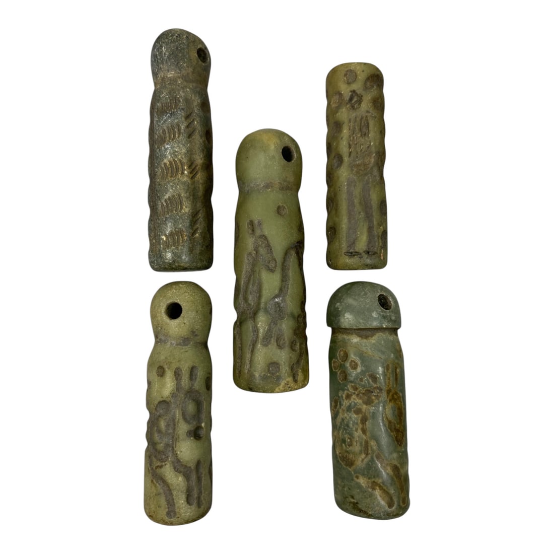 A Lot of 5 Ancient Mesopotamian Serpentine Cylinder Seals, 42WP: A curated lot of five ancient Mesopotamian-style cylinder seals, carved from serpentine stone with natural patination and wear consistent with age. Each seal features a domed top with a suspension hol