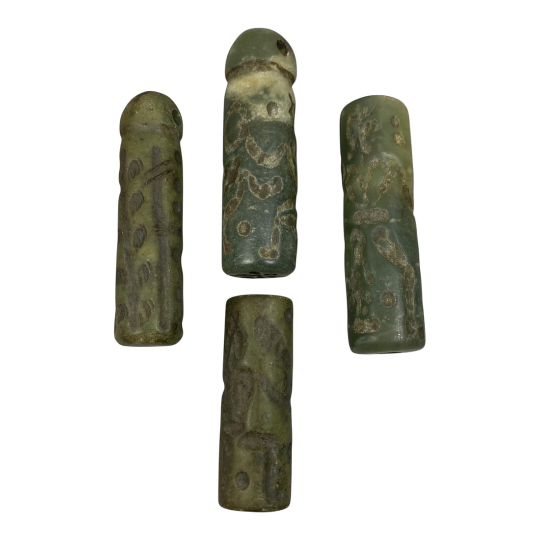 A Lot of 4 Ancient Mesopotamian Serpentine Cylinder Seals, 45WP: A curated lot of four ancient Mesopotamian-style cylinder seals, carved from serpentine stone with natural patination and wear consistent with age. Three seals feature domed tops with suspension holes