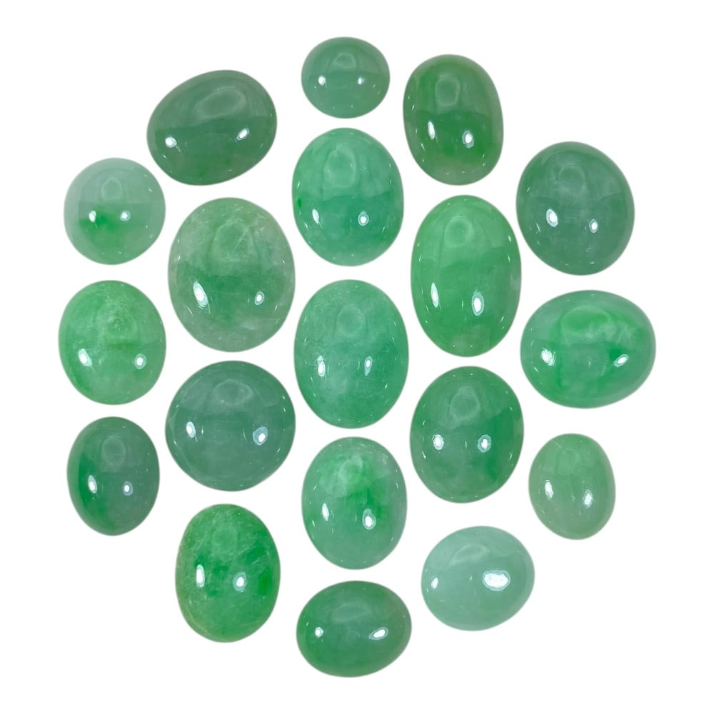 A Lot of 19 Natural Apple Green Jadeite Jade Cabochons, 85ct Total, 30AB: This collection features 19 polished jadeite jade cabochons in a range of soft to vibrant apple green hues, from pale translucent tones to richer saturated shades. The stones are primarily oval and ro