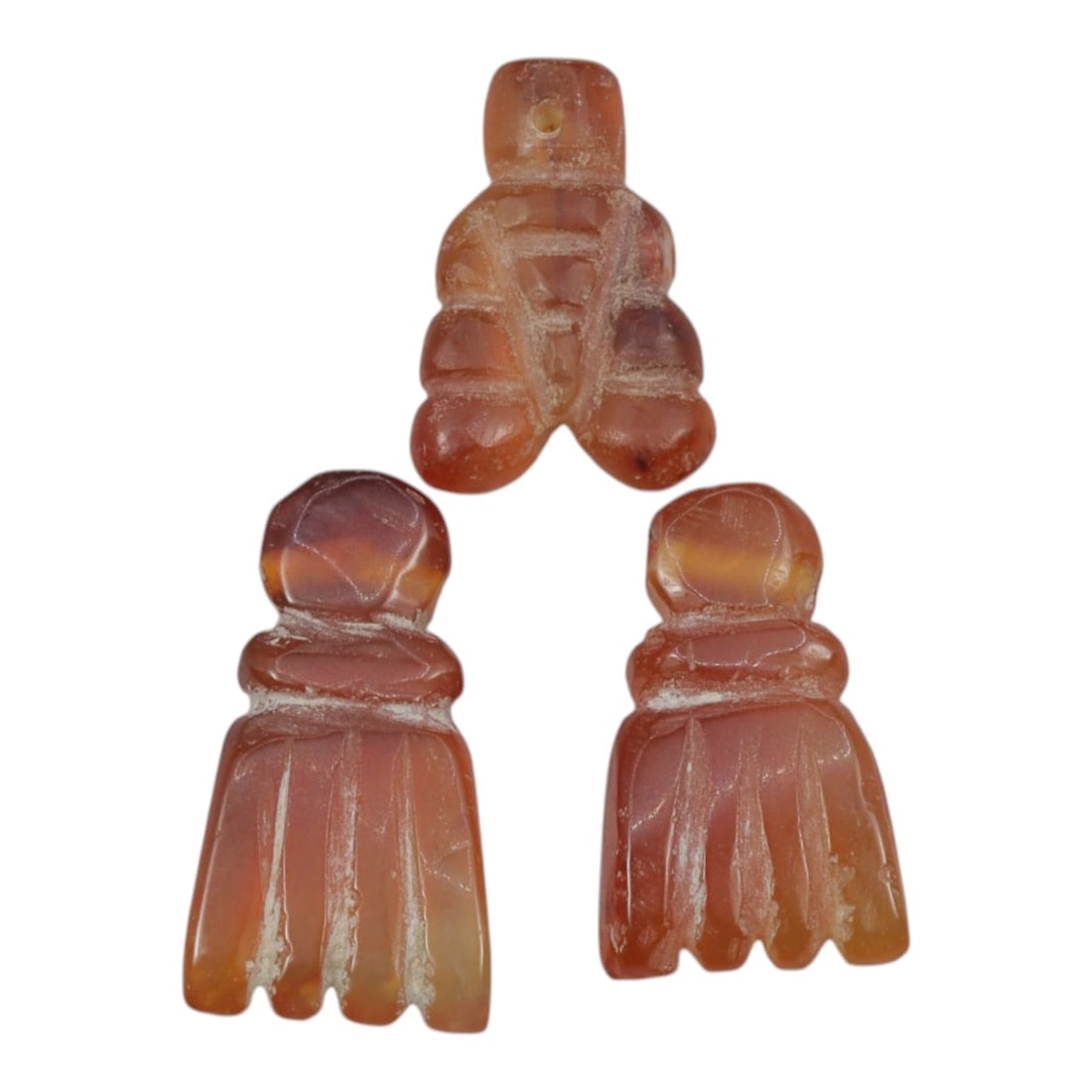 Lot of 3 Ancient Coptic Egyptian Carnelian Amulets, c. Roman Period to Coptic Era, 20WL: Carved from warm, translucent carnelian with natural orange-red hues and subtle weathering, this set includes three stylized amulets: one anthropomorphic form and two open-hand motifs, each with drill