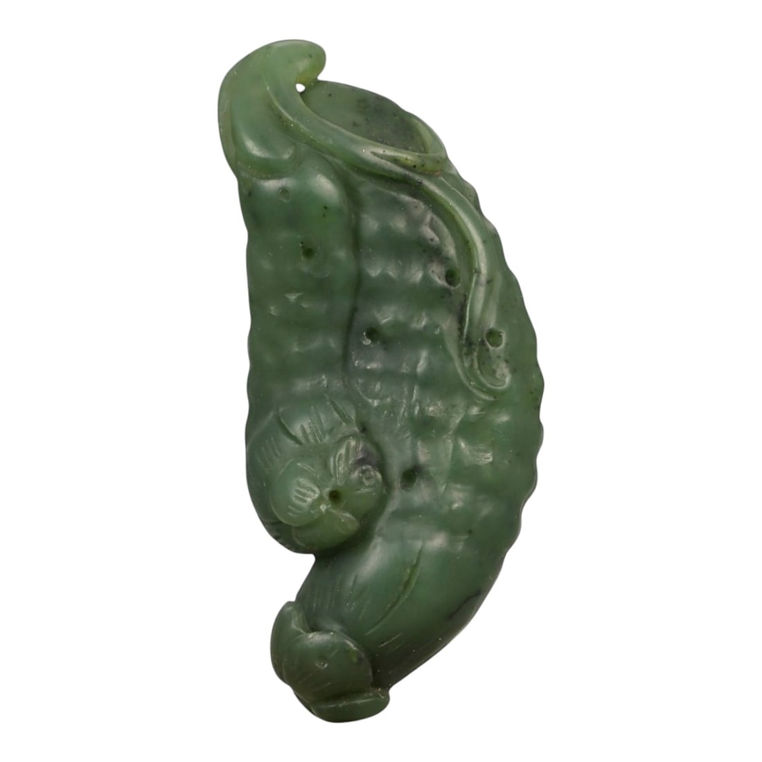 A Chinese Nephrite Jade Fruit Pendant, 20th Century, 76FA: Carved from dark green nephrite jade with lighter mottling and scattered natural inclusions, the pendant is worked in the round to depict an elongated fruit form, likely a gourd or melon, shown in a g