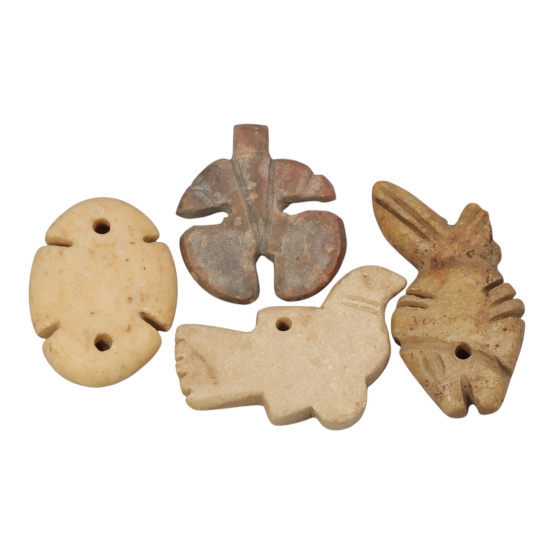 Lot of 4 Ancient Coptic Egyptian Stone Amulets, Circa Roman to Coptic Era, 73WL: Carved from light beige and tan stone with natural patination, this set includes four distinct stylized forms: a double-perforated oval pendant, a cross-shaped floral amulet, a bird-shaped charm, and 
