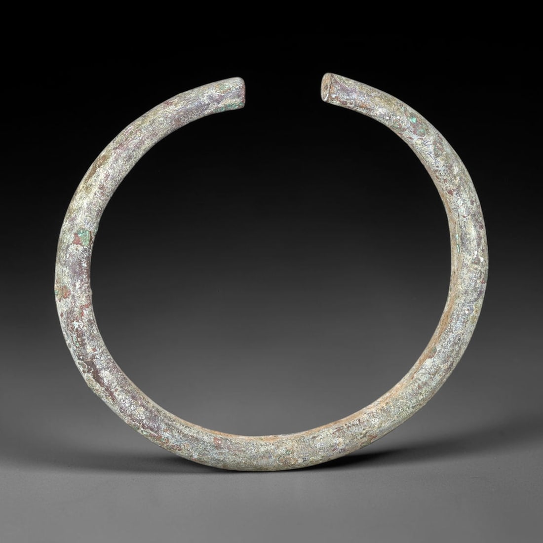 Ancient Bronze Bracelet - Roman Open Bangle, 89BN: An open-form bracelet crafted from cast bronze, with a robust rounded cross-section and simple, flat terminals. The form adheres to the utilitarian aesthetic of Roman provincial jewelry, designed for 