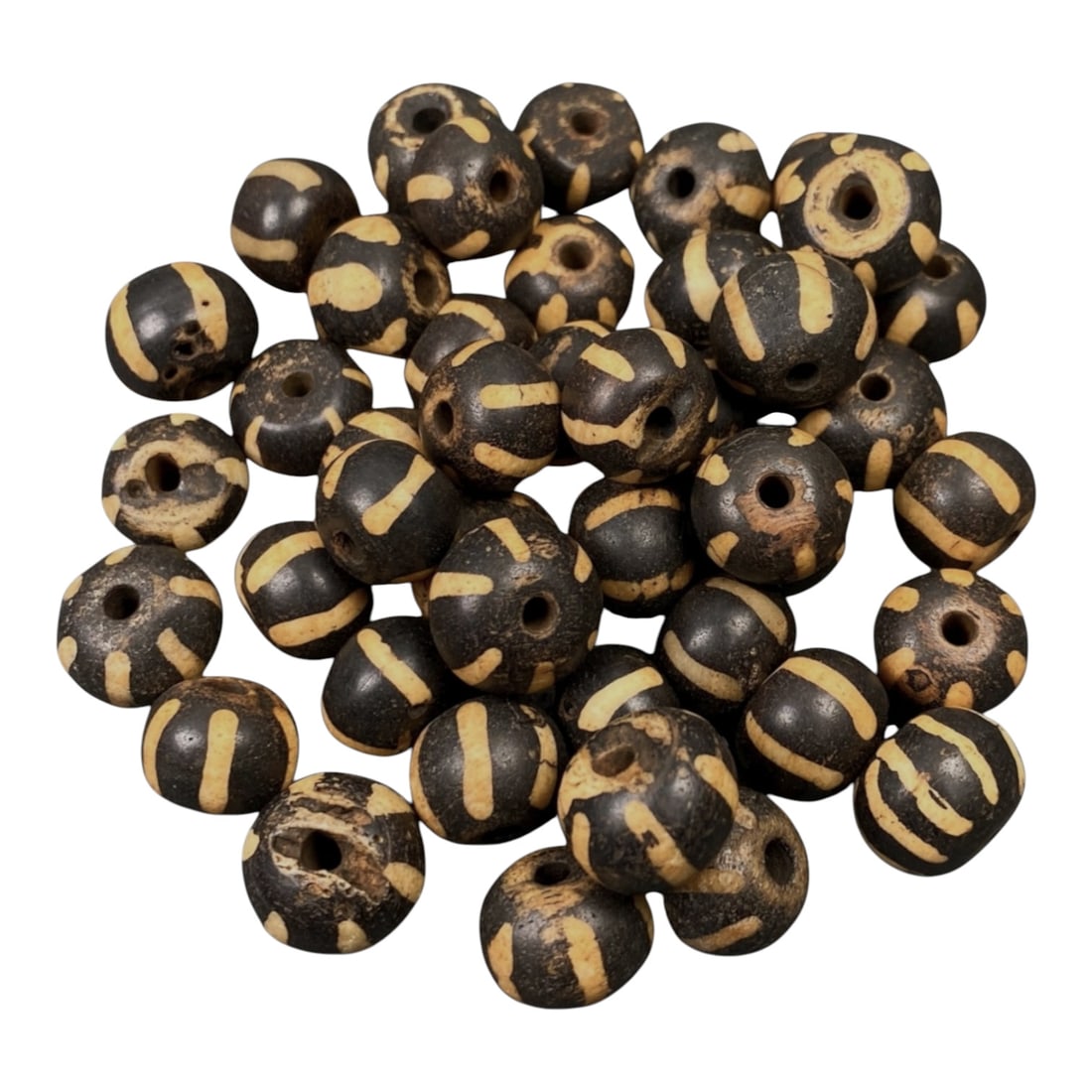 Lot of 43 Antique Indo-Himalayan Pumtek Wood Beads, 55AG: A group of 43 antique Indo-Himalayan pumtek wood beads, each with a rounded disc form and central perforation. The beads feature a dark, polished base with light yellowish geometric and linear pattern