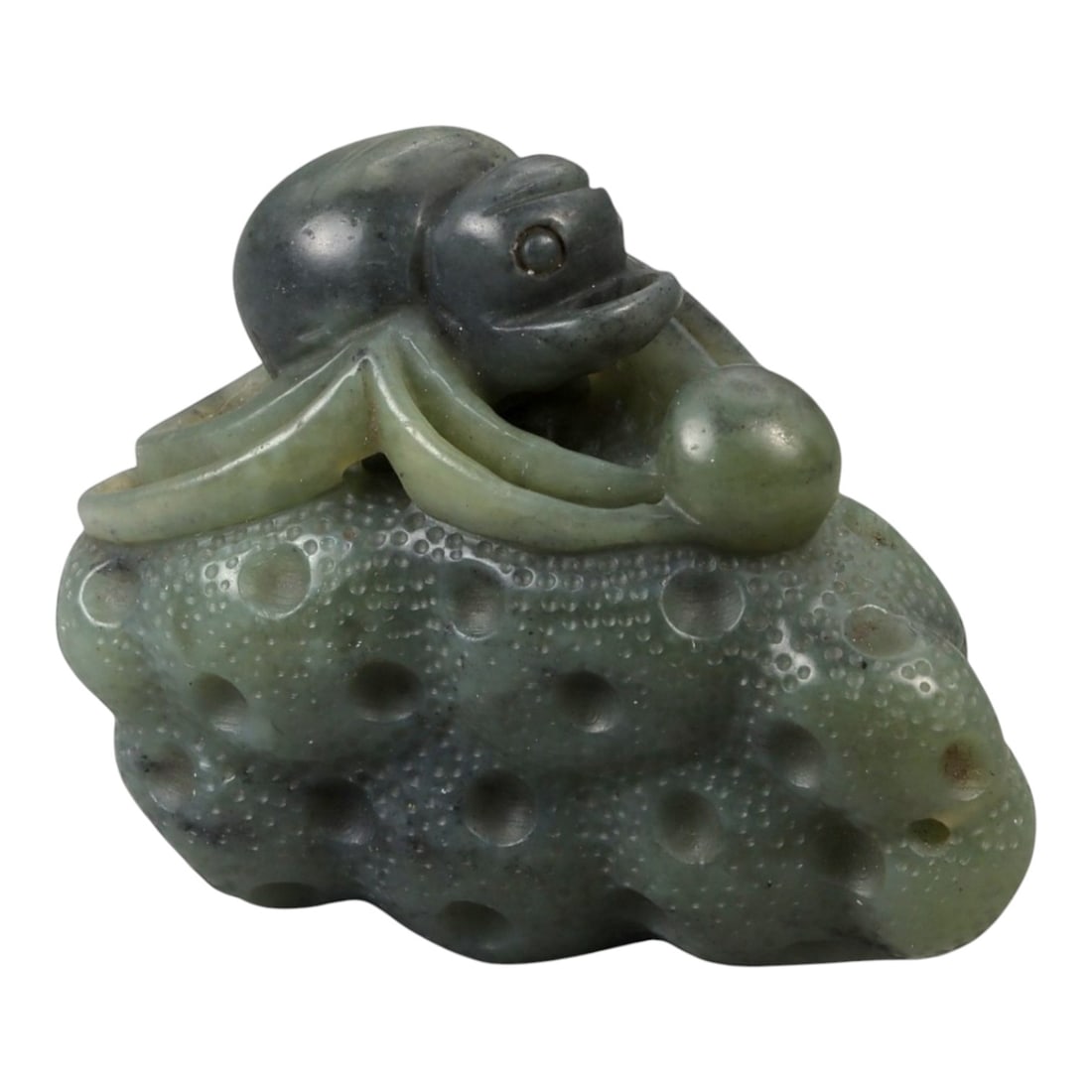 A Chinese Nephrite Jade Spider on Fruit Carving, 20th Century, 79FB: Carved from mottled green and dark gray nephrite jade with subtle translucency, this small sculptural carving depicts a spider perched atop a fruit, rendered in the round with strong attention to text