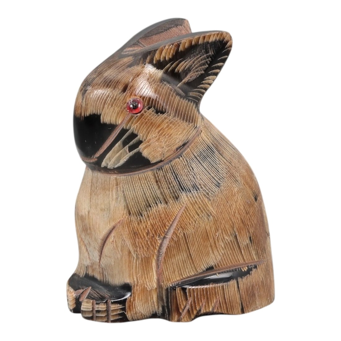 An East Asian Ox Horn Rabbit Effigy, 20th Century, 7FJ: Carved from a single section of ox horn with visible natural striations and tonal variation ranging from pale honey to deep brown, the object is formed as a seated rabbit rendered in the round. The he