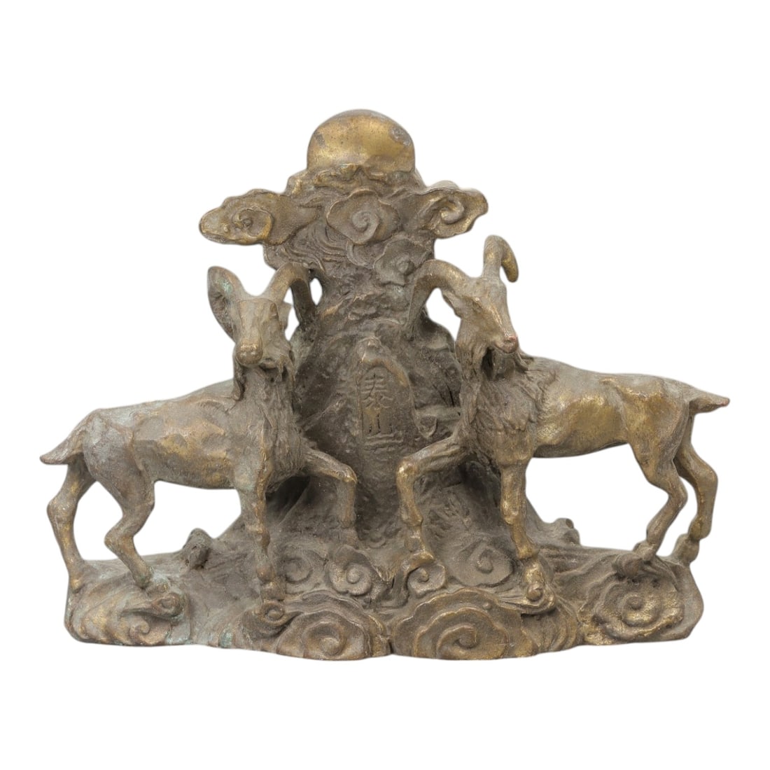 A Chinese Bronze Ram Group, 20th Century, 20FH: Cast in bronze with a dark brown surface and areas of lighter wear, the sculpture depicts a symmetrical group of two rams arranged on either side of a central vertical element. Each ram is shown stand