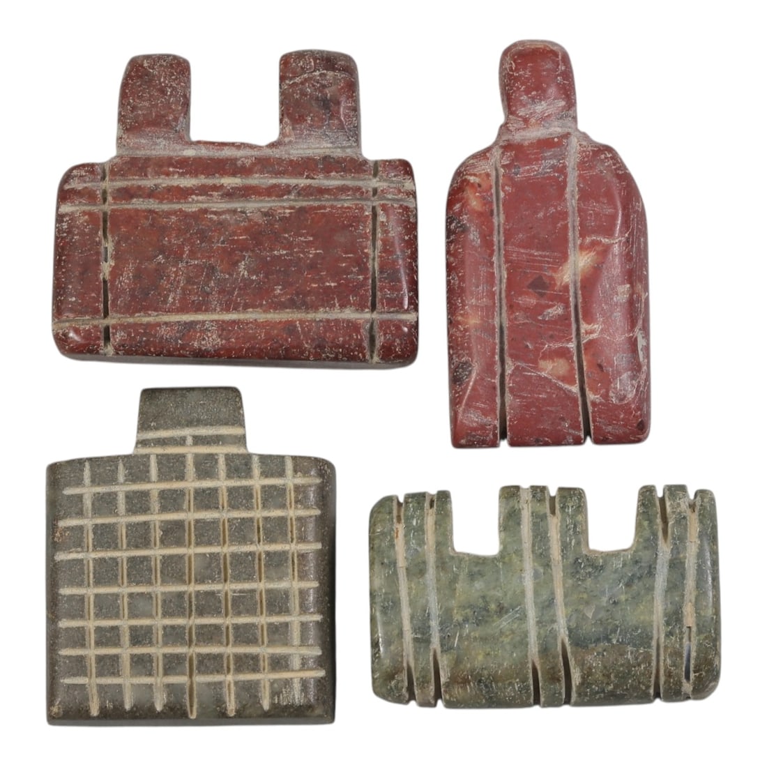 Lot of 4 Islamic Period Stone Amulets, Circa Medieval Period, 43AE: The group comprises four carved stone amulets of varied geometric forms, characteristic of Islamic-period talismanic objects. The pieces are worked in red, grey, and green stone, each exhibiting surfa