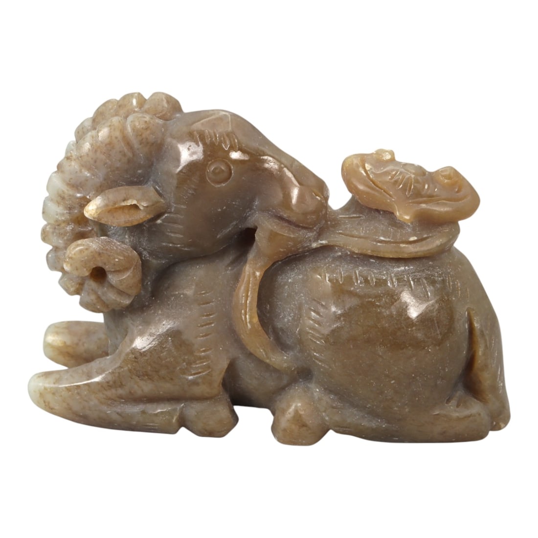 A Chinese Jade Carving of a Recumbent Ram with Lingzhi, 20th Century, 25YA: Carved from mottled buff and pale brown jade with subtle translucent areas, the sculpture is modeled as a recumbent ram resting with its legs folded beneath the body. The head is turned slightly to on
