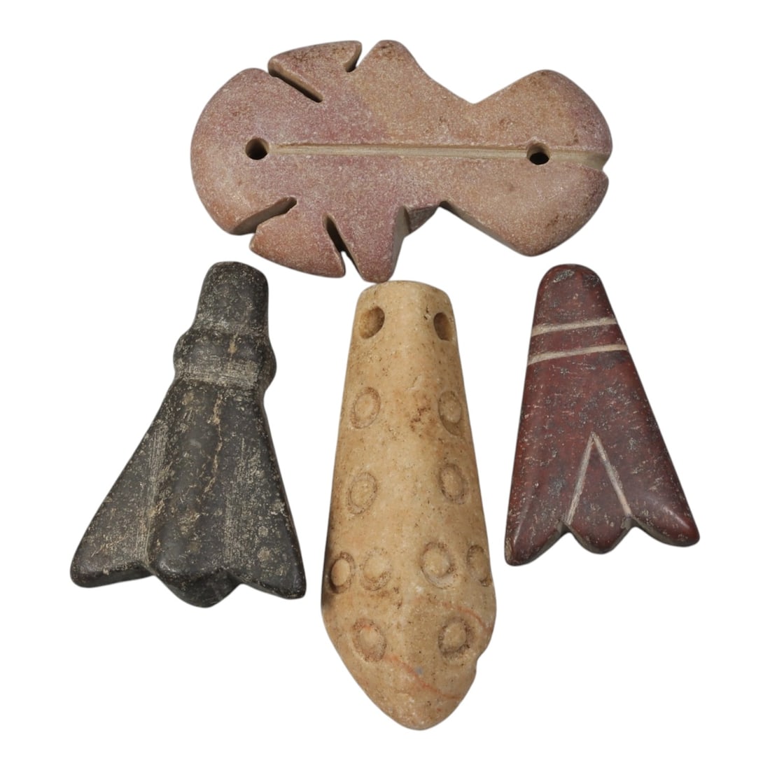 Lot of 4 Coptic Egyptian Stone Amulets, Roman to Coptic Period, 53AE: A group of four stone amulets from the Coptic period, each carved in distinct forms and colors. The top amulet is a pinkish stone, shaped with symmetrical cutouts and a central perforation line. The b