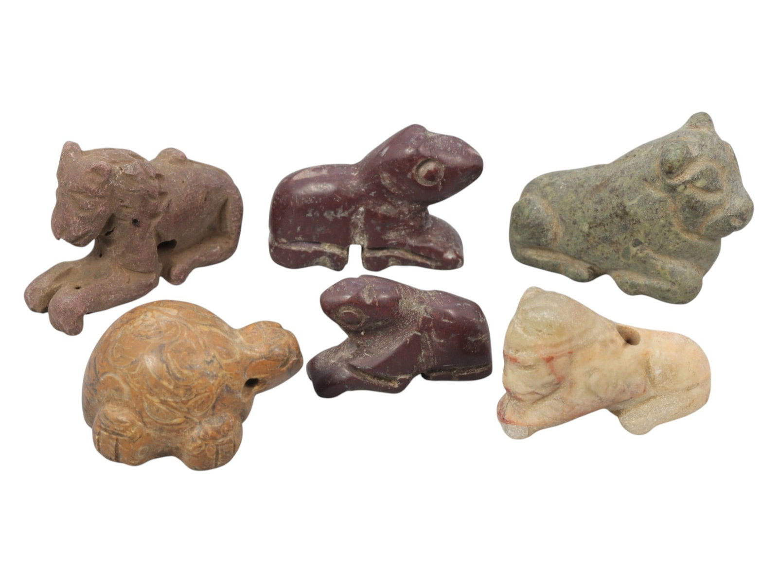 Lot of 6 Ancient Near Eastern Zoomorphic Stone Amulets, c. Iron Age to Sasanian Period, 86WK: A diverse collection of six zoomorphic stone amulets from the Ancient Near East, carved from varied materials including red, green, brown, and pale stone. The set features stylized recumbent animals, 