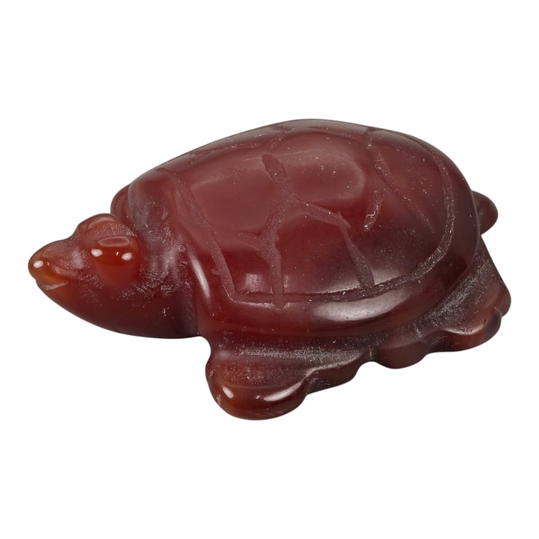 A Chinese Carnelian Tortoise Carving, 20th Century, 54YB: Carved from translucent reddish-brown carnelian with lighter clouding and natural tonal variation, the figure represents a tortoise shown recumbent with the head extended and the limbs folded beneath 