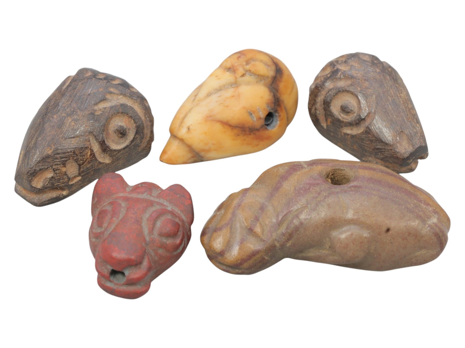 Lot of 5 Ancient Near Eastern Zoomorphic Amulets, c. Iron Age to Sasanian Period, 91WK: A diverse collection of five zoomorphic amulets from the Ancient Near East, carved from varied materials including stone, bone, and possibly terracotta. The set includes stylized animal heads (likely 