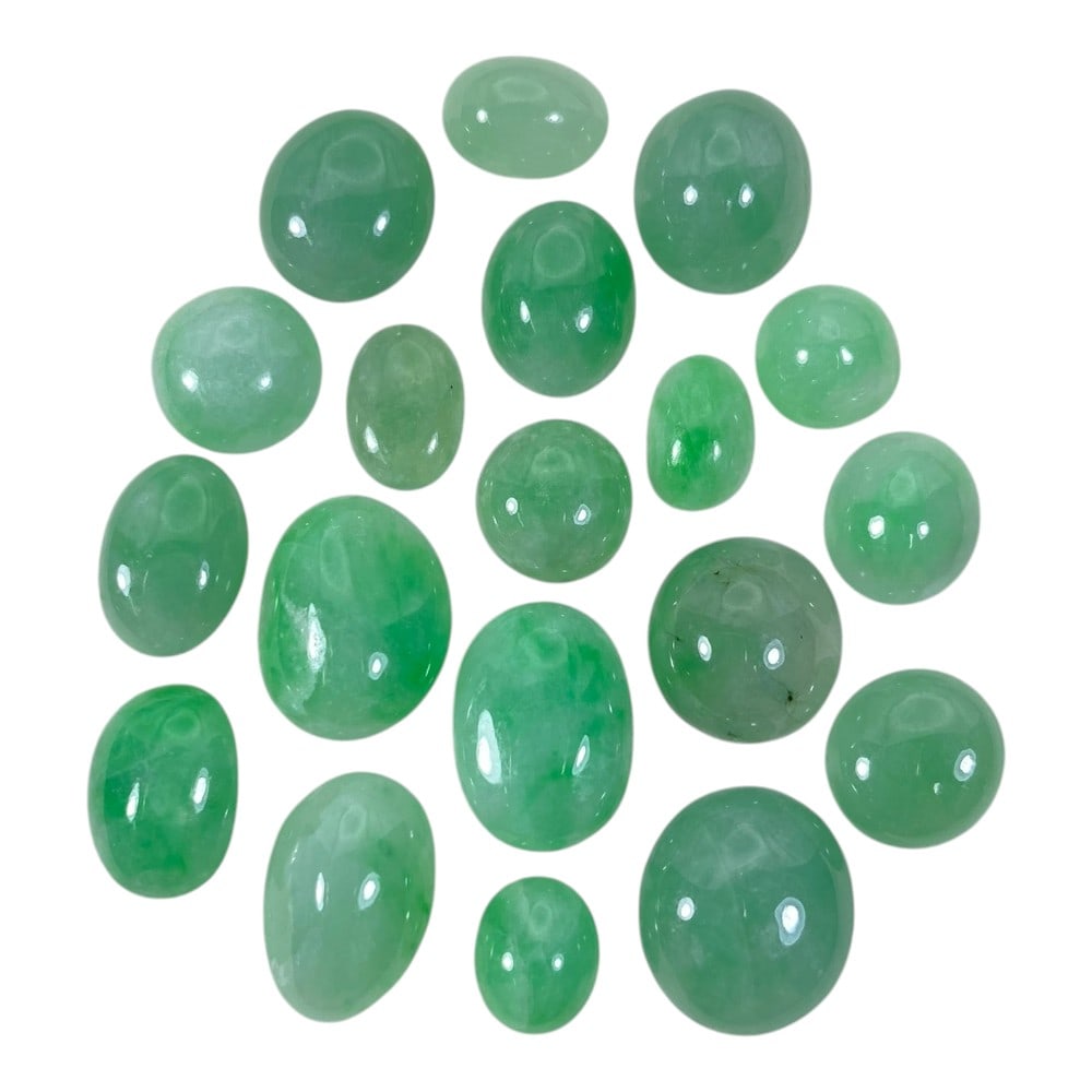 A Lot of 19 NaturaL Apple Green Jadeite Jade Cabochons, 86.35ct Total, 28AB: This collection features 19 polished jadeite jade cabochons in soft to vibrant apple green hues, ranging from pale translucent tones to richer saturated shades. The stones are primarily oval and round