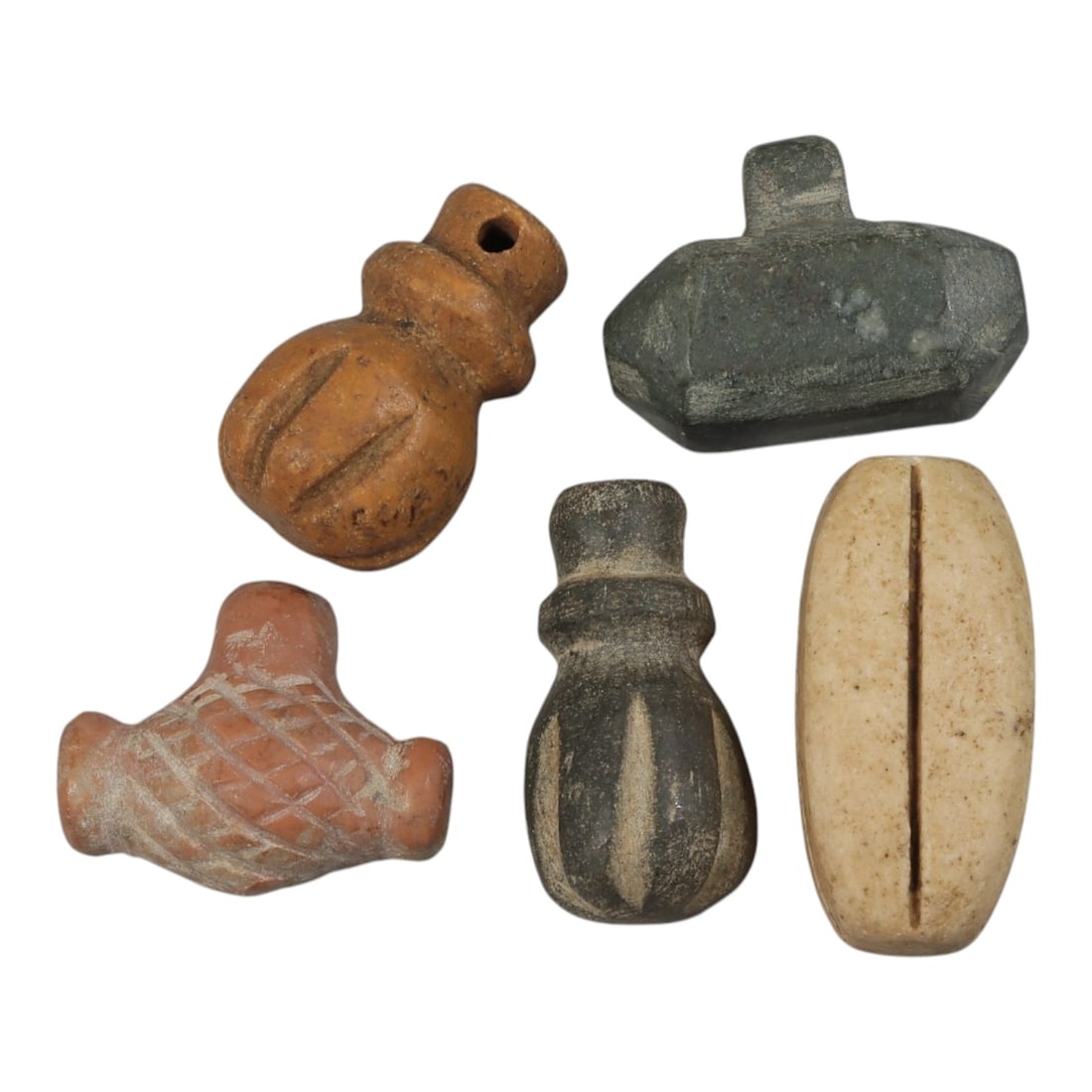 Lot of 5 Ancient Near Eastern and Coptic Amulets, 1st Millennium BCE to Islamic Period, 89AE: Comprising five small amulets of varying material and form. One terracotta gourd-shaped pendant with incised vertical lines and suspension hole. One dark green stone polygonal pendant with suspension 
