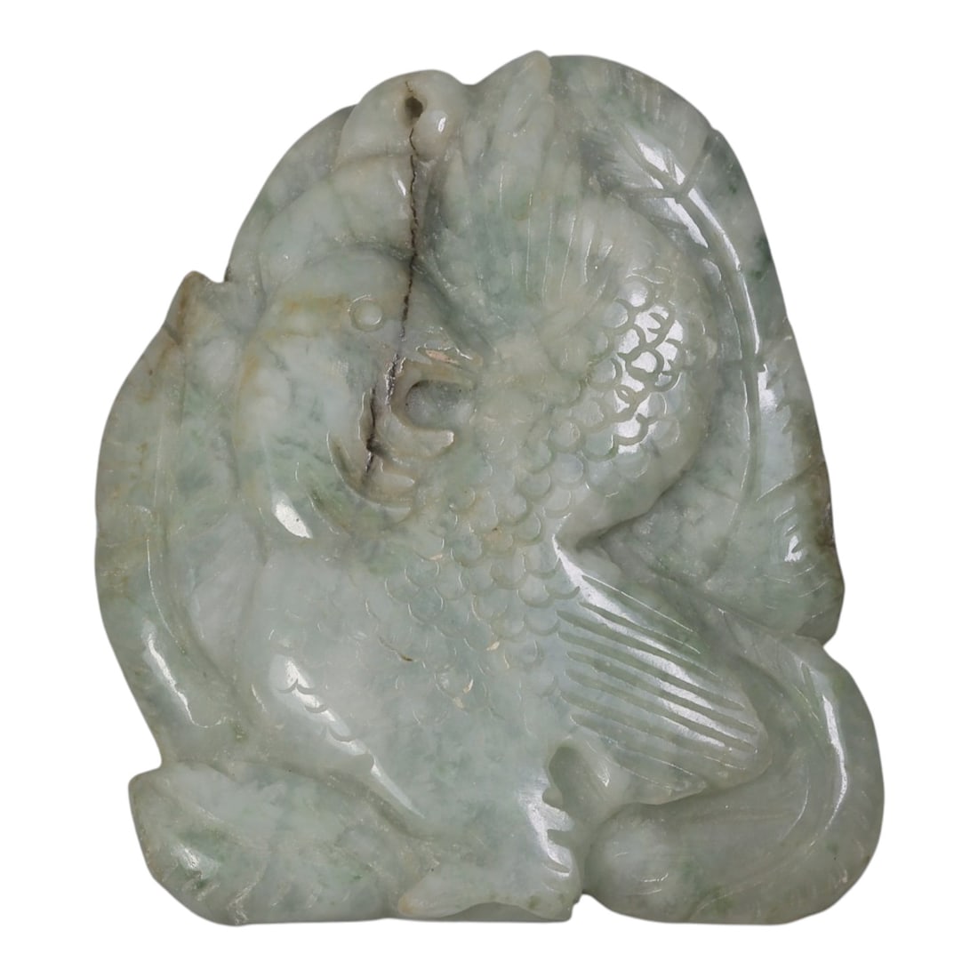 An Antique Oriental Chinese Jadeite Jade Bird Pendant, 51AG: Carved from pale greenish-white jadeite with natural mottling and faint green inclusions, the pendant depicts a stylized bird with detailed scaled plumage, incised wing feathers, and a defined eye and