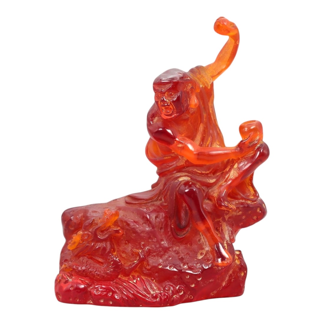A Chinese Amber-Resin Figure of a Luohan, 20th Century, 34FH: Cast or carved from translucent amber-colored red resin with internal tonal variation, scattered inclusions, and small entrapped bubbles, the figure represents a luohan shown seated in a dynamic postu
