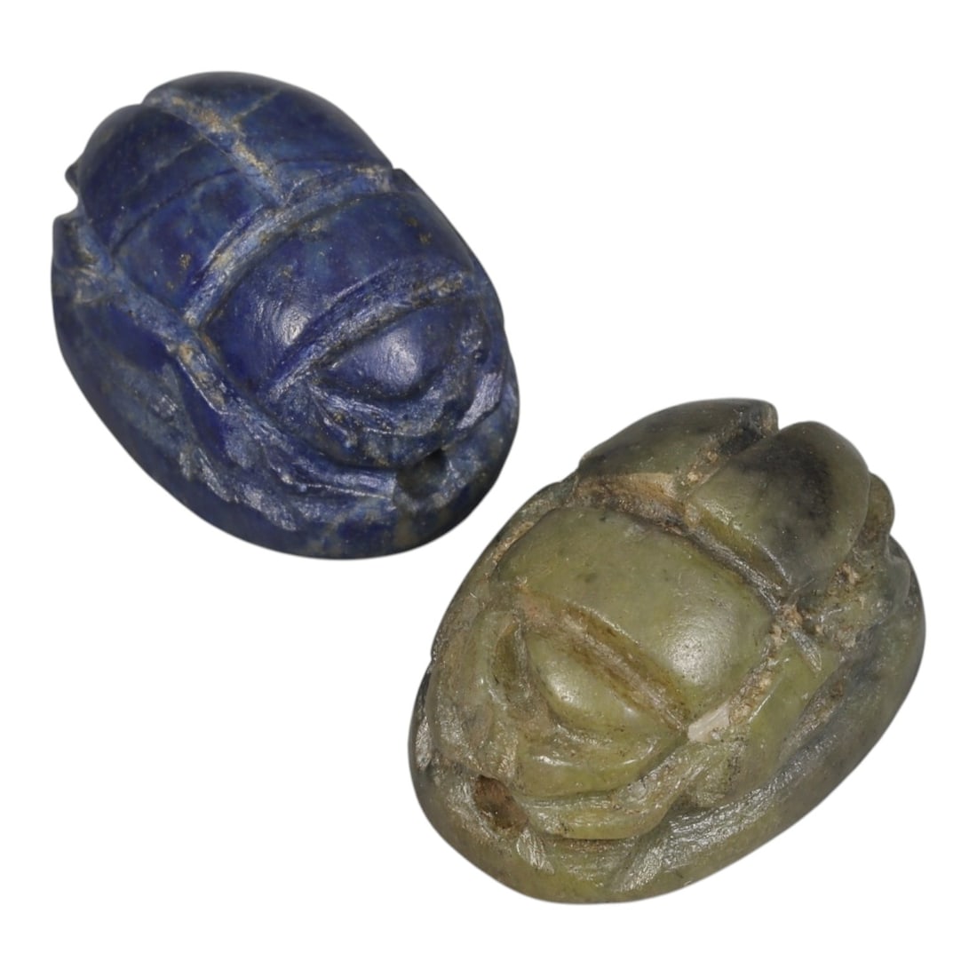 Lot of 2 Ancient Coptic Egyptian Scarabs, Circa Roman to Coptic Era, 93AE: The group comprises two scarab amulets, one carved from lapis lazuli and one from greenish stone. The lapis lazuli example retains the characteristic deep blue hue with subtle natural inclusions, carv
