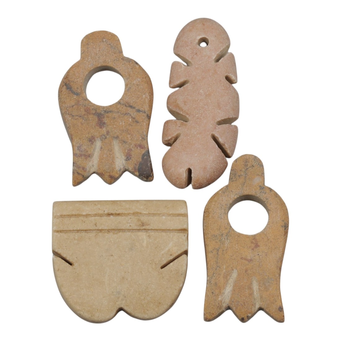 Lot of 4 Ancient Coptic Egyptian Stone Amulets, Circa Roman to Coptic Era, 6WL: Crafted from warm beige, tan, and pinkish stone, this set of four amulets features varied stylized forms: a tulip-shaped pendant, a heart or shell form, a bird with a central aperture, and a feather-s