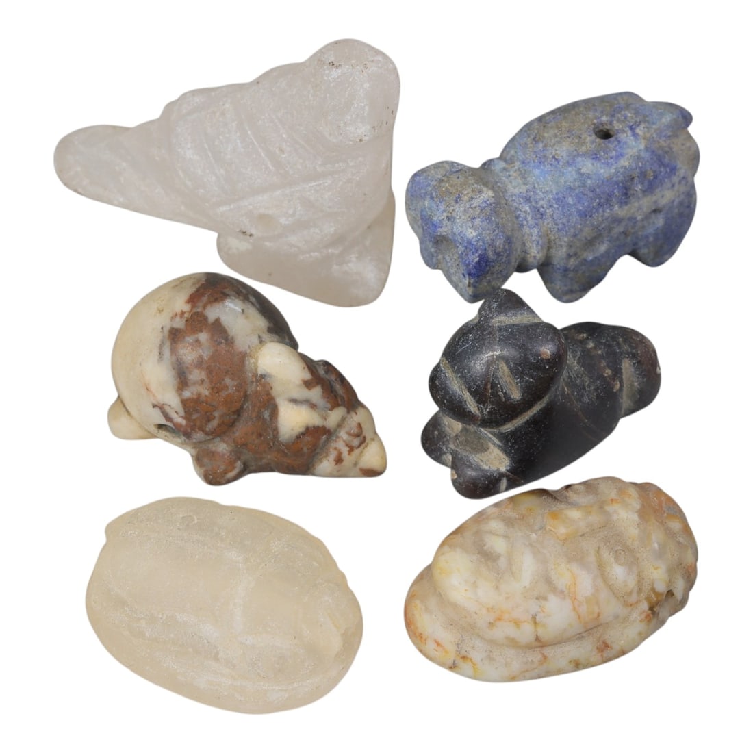 Lot of 6 Ancient Near Eastern Stone Amulets, Circa 1st Millennium BCE, 81AE: Comprising six zoomorphic and scaraboid amulets of varying stone materials. One translucent white stone bird-shaped amulet with incised feather details. One lapis lazuli quadruped figure with suspensi