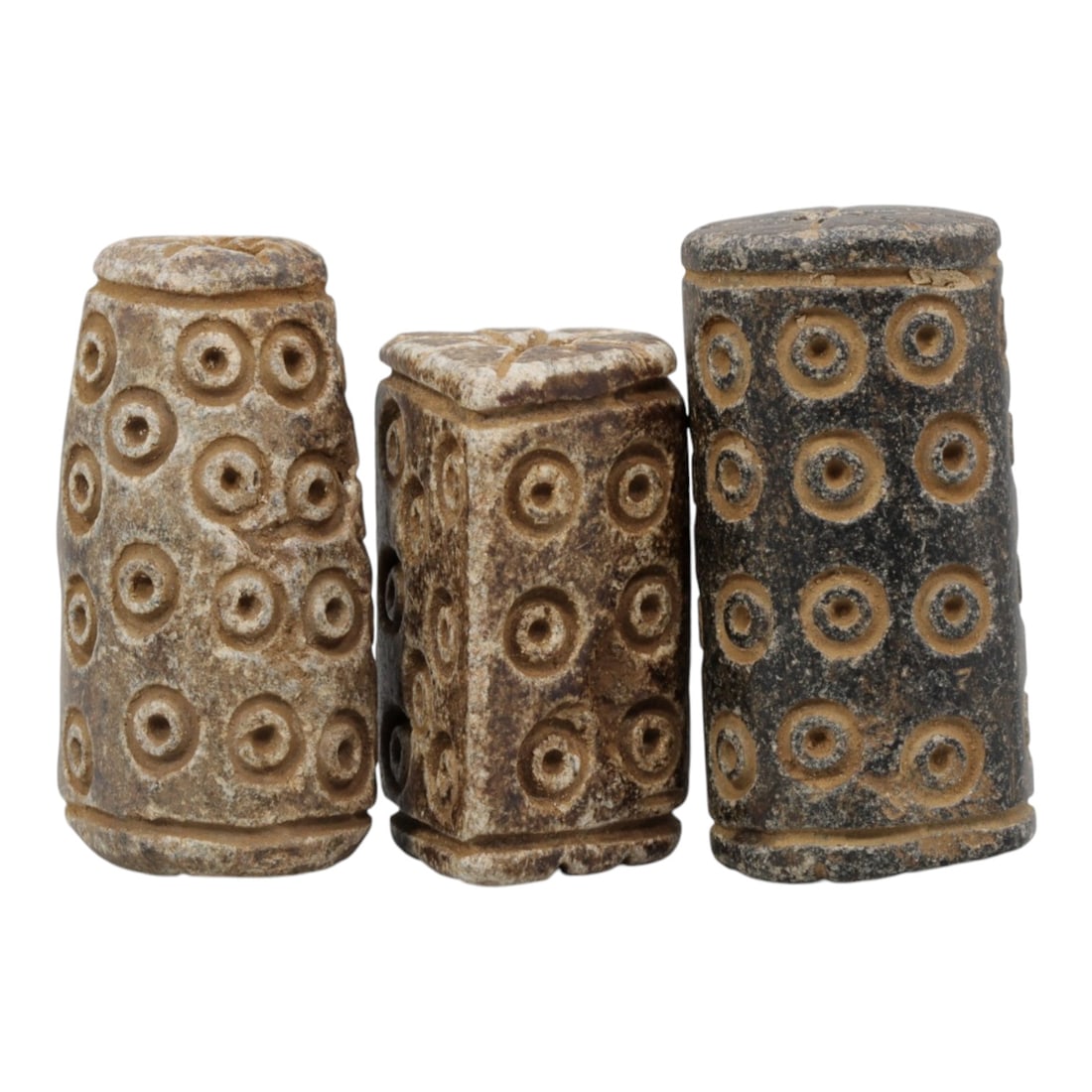 Lot of 3 Ancient Schist Beads/Seals with Incised Concentric Circles, 97WL: A group of three hand-carved stone objects crafted from schist, exhibiting natural earthy tones ranging from light beige to dark grey, with heavy surface patination, wear, and subtle weathering consis