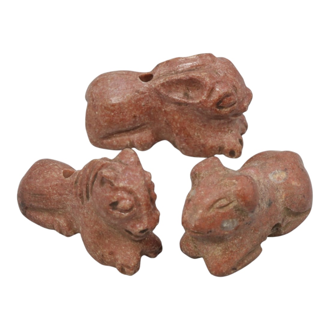 Lot of 3 Ancient Bactrian Zoomorphic Amulets, Circa 3rd-1st Millennium BCE, 14WM: A group of three carved stone zoomorphic amulets, each depicting a quadruped animal (including rabbit and feline forms) in a recumbent pose. The amulets are crafted from a uniform warm reddish stone, 