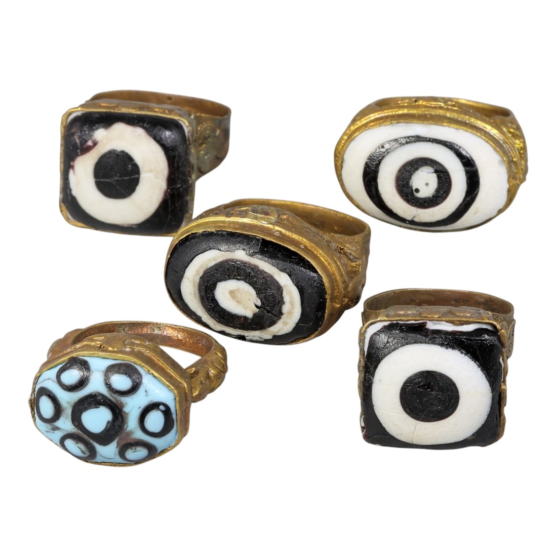 Lot of 5 Antique Qajar Period Gilt Evil Eye Glass Rings, 99AC: A collection of five antique gilt-metal rings from the Qajar period (19th century), each adorned with traditional "evil eye" glass cabochons. The set includes four classic black-and-white concentric b