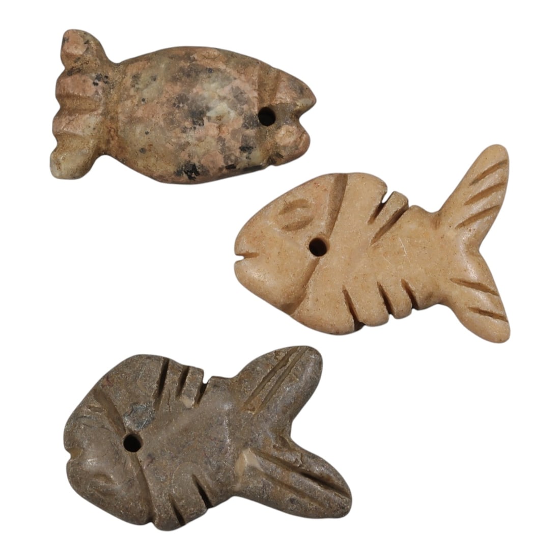 Lot of 3 Ancient Coptic Egyptian Stone Fish Amulets, Circa Roman to Coptic Era, 86AE: The group comprises three carved stone fish amulets, each rendered in stylized form with incised details defining the eyes, fins, and body segments. The pieces are worked in varied stone tones: mottle