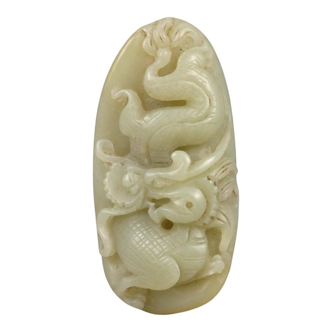 A Chinese Nephrite Jade Dragon Pendant, 20th Century, 57FA: Carved from pale cream nephrite jade with areas of soft translucency and minor natural inclusions, the pendant is worked in high relief depicting a sinuous dragon shown in a vertical, ascending postur