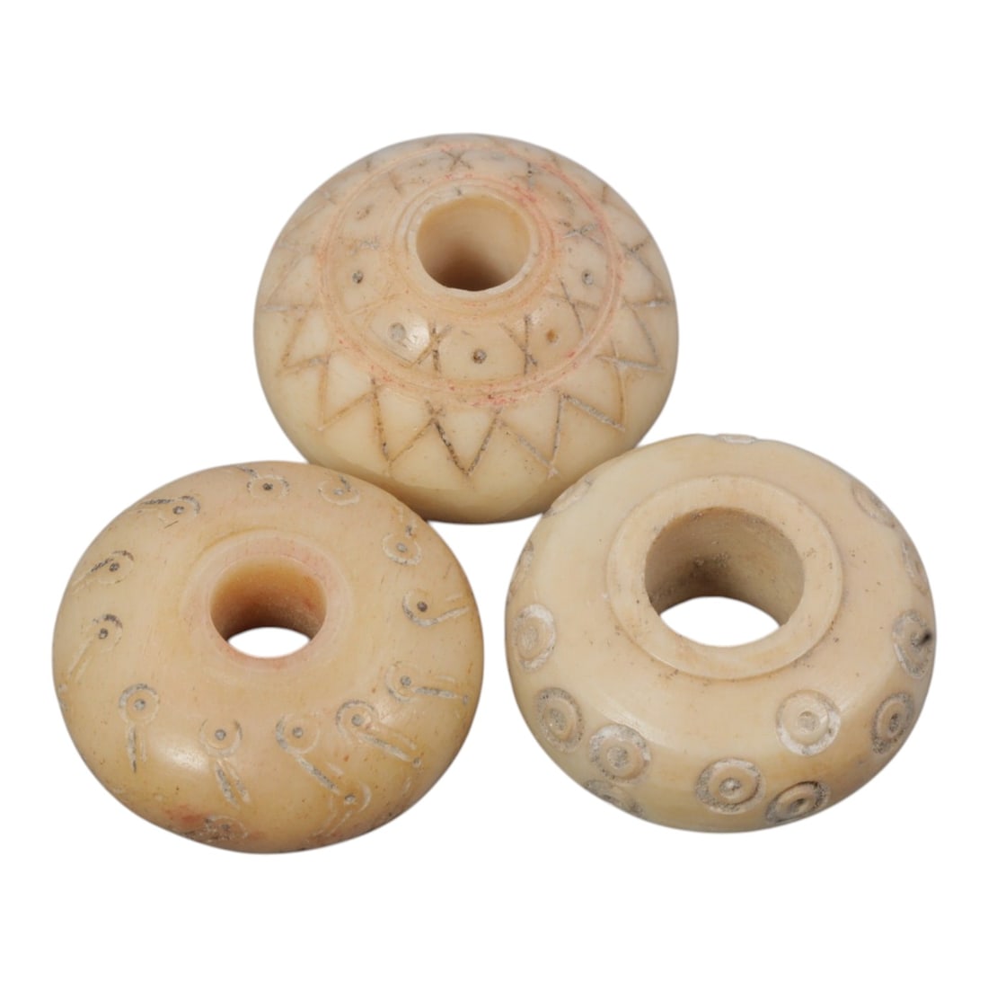 A Lot of 3 Ancient Silk Road Bone Spindle Whorls, 1WL: Three disc-shaped bone spindle whorls, each with a central perforation intended for mounting on a spindle shaft. Each example features distinct incised decoration: one displays a repeating geometric z