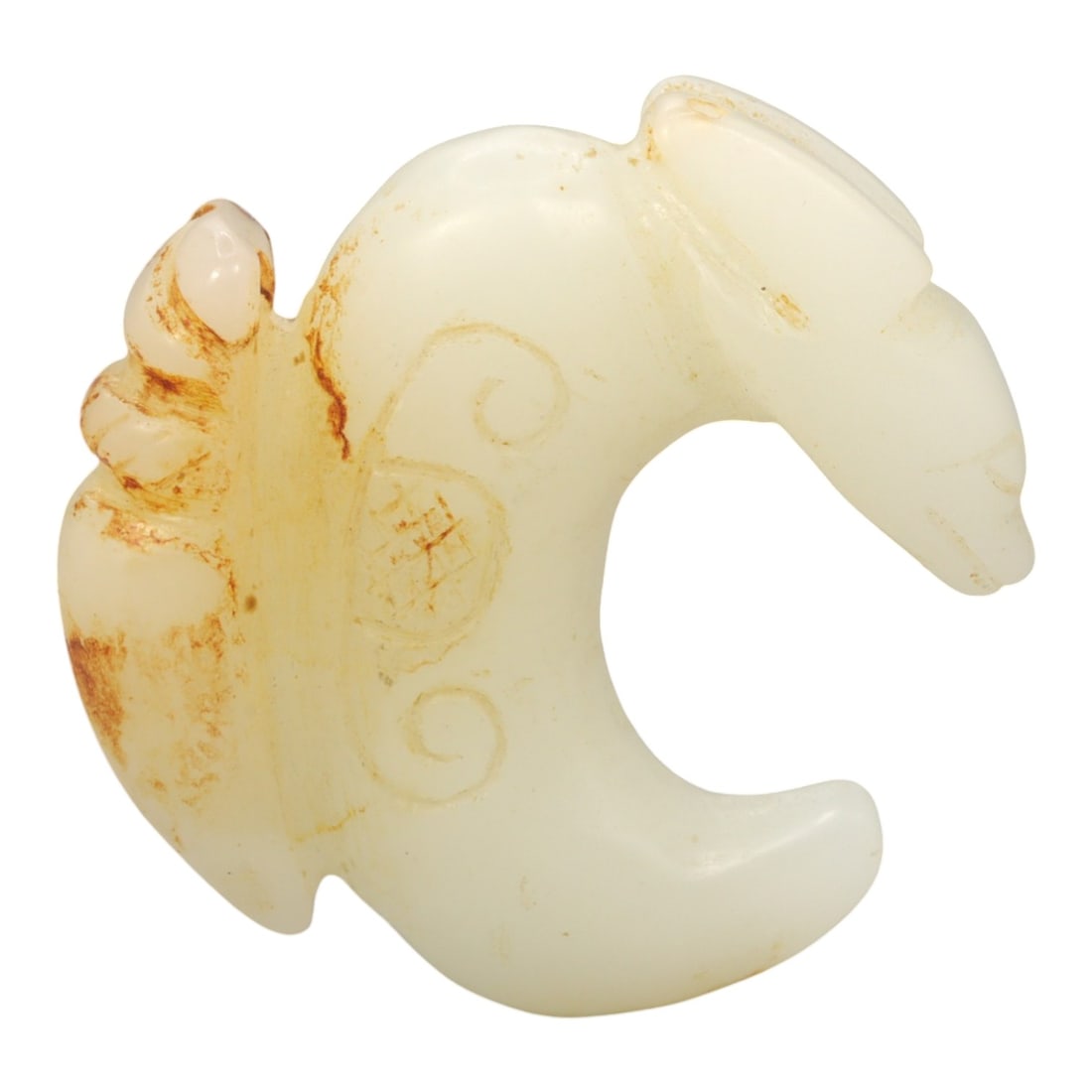 A Chinese Hetian Jade Zoomorphic Ornament, 20th Century, Ancient Style, 83FH: Carved from pale creamy-white Hetian jade with areas of natural russet-brown staining, the ornament is worked in the form of a stylized animal rendered in a compact, curved silhouette. The head is cle
