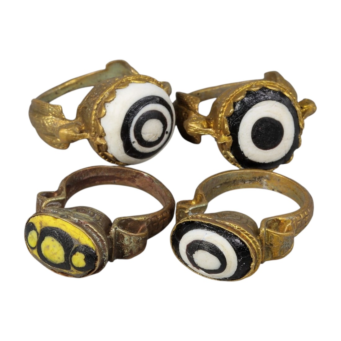 Lot of 4 Antique Qajar Period Gilt Evil Eye Glass Rings, 13AD: This is a collection of four antique rings from the Qajar period (19th century), each set with traditional "evil eye" glass cabochons. Three rings feature classic black-and-white concentric bullseye p